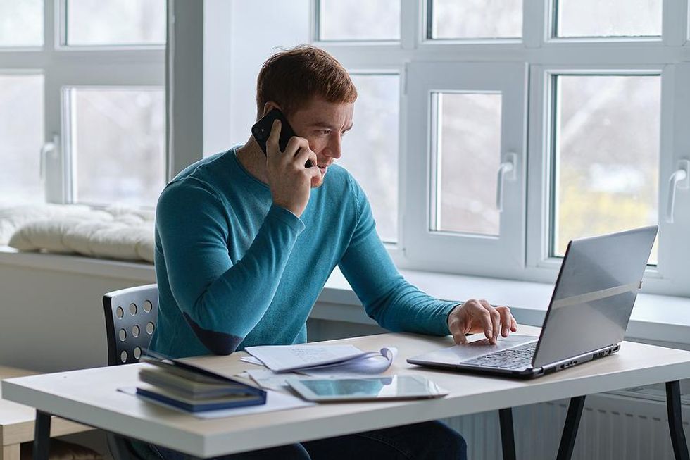 A job seeker on laptop works on his resume and cover letter