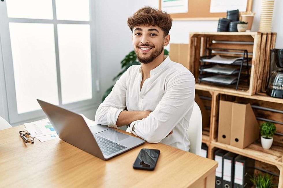 Happy man looks for a job on his laptop