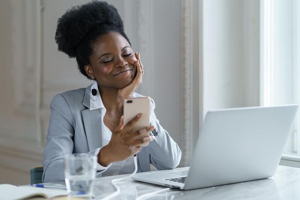 Happy woman on phone connects with someone on LinkedIn
