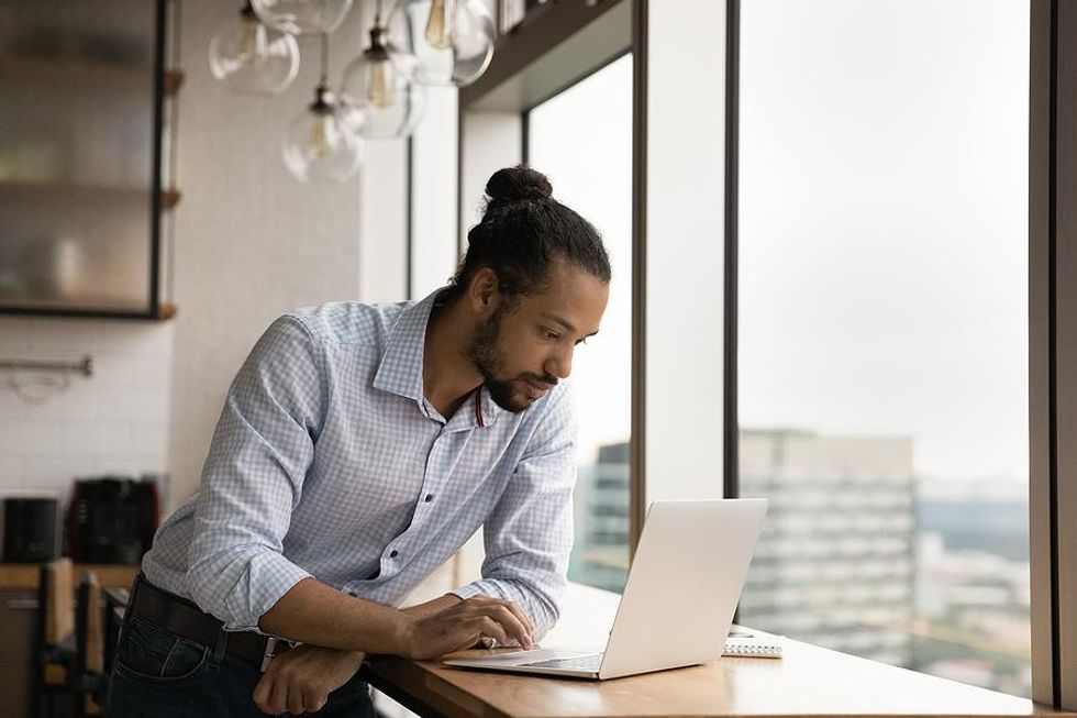 Job seeker on laptop reviews his resume