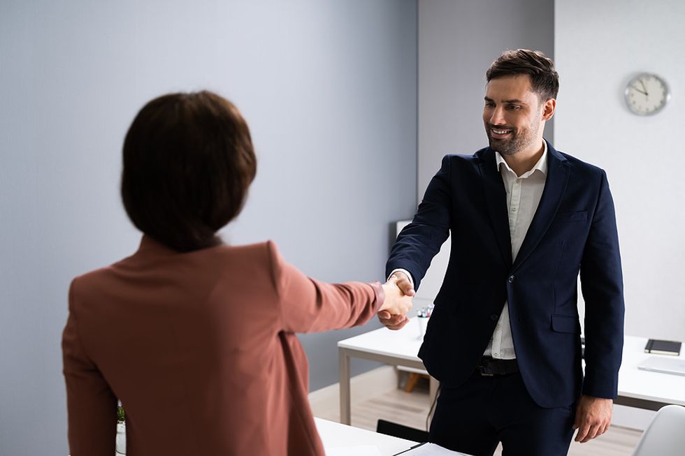 Job seeker shakes hands with the hiring manager and tells them they want the job