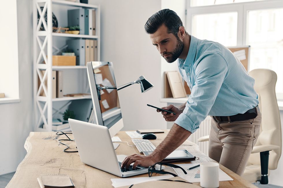 Man fixing his resume on his laptop and tailoring it for a leadership role