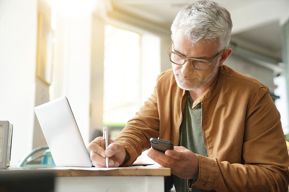 Man looking at phone makes a list of his professional references