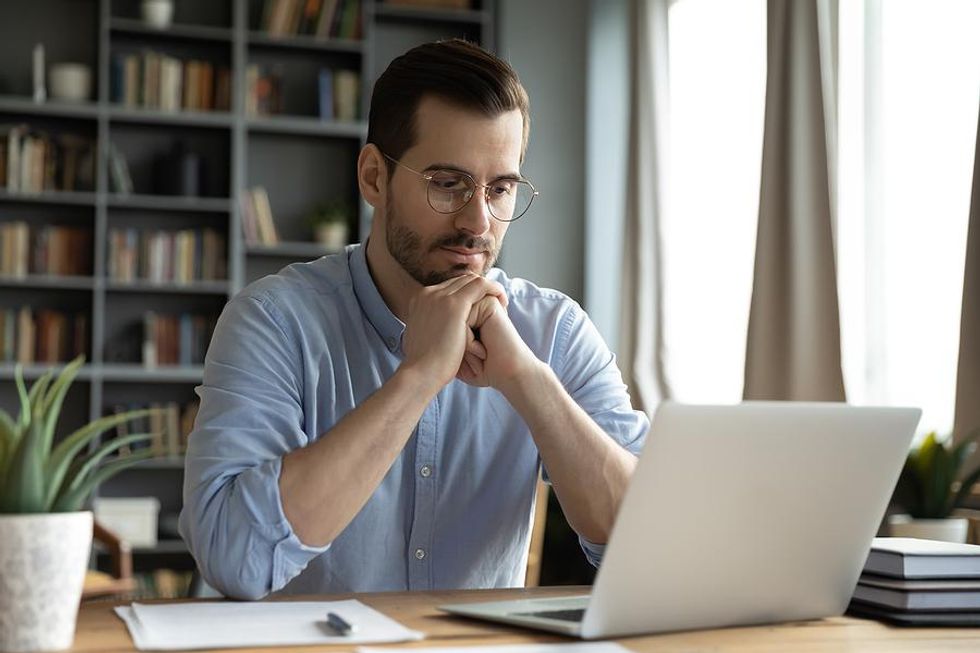 Man on laptop experiences job burnout