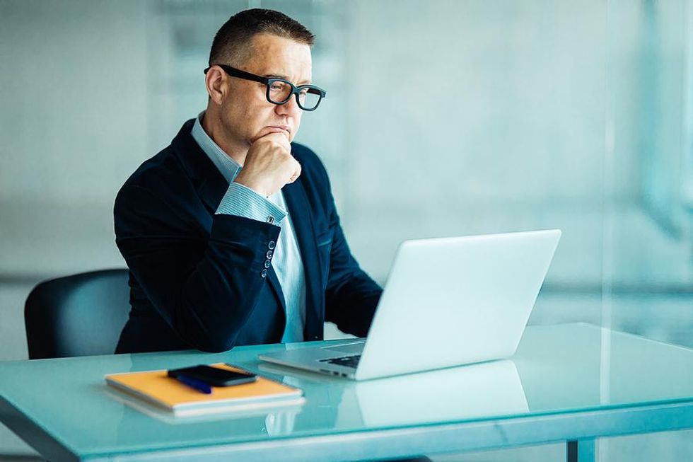 Man on laptop looks at the work experience on his resume