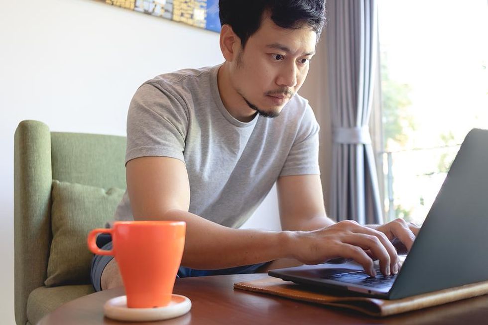 Man on laptop researches a company to avoid a job search scam