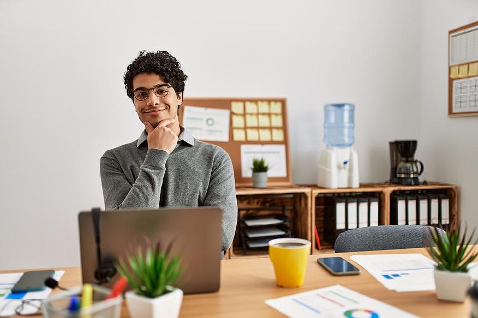 Man on laptop thinks about his career accomplishments
