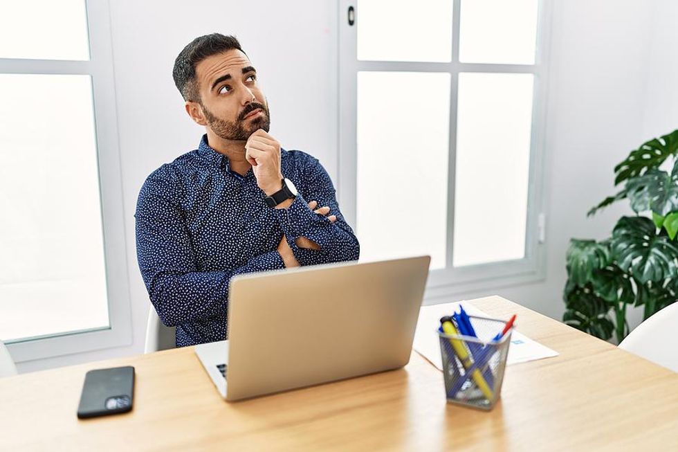 Man on laptop thinks about his job search