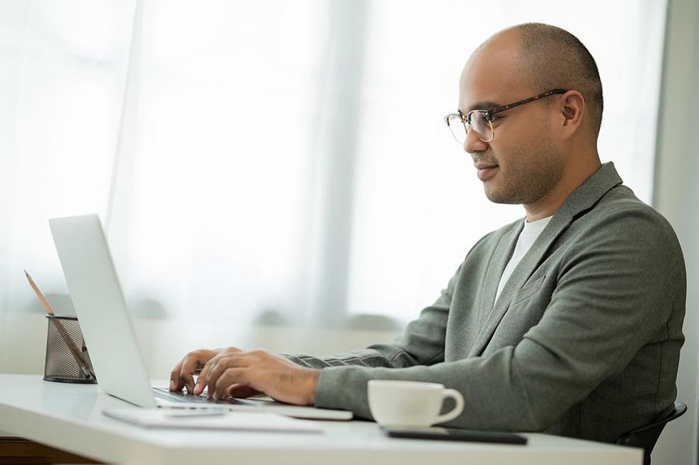 Man on laptop updates his LinkedIn profile