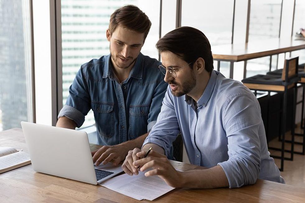 Man talks to a career coach while looking for a job on his laptop