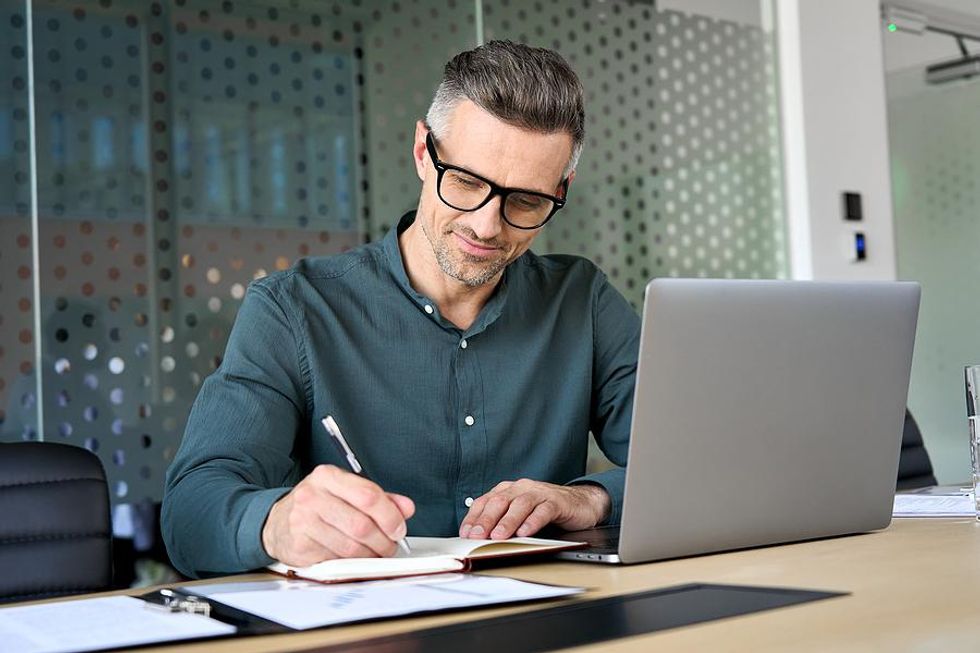 Man writes a job-matching matrix in his job search