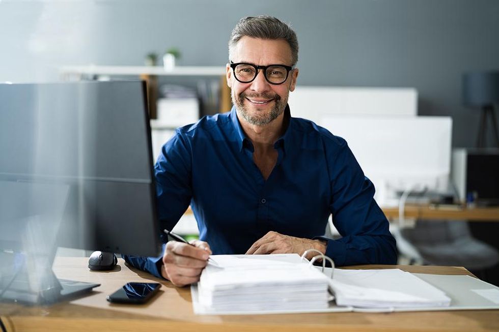 Older professional smiles while at work