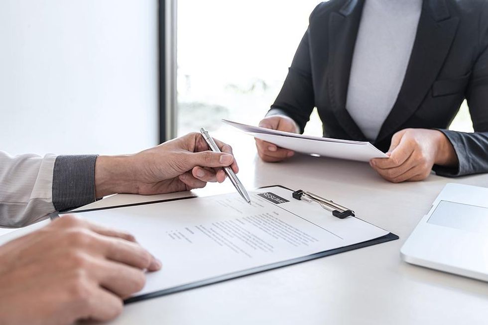 Recruiters look at a job candidate's resume during an interview