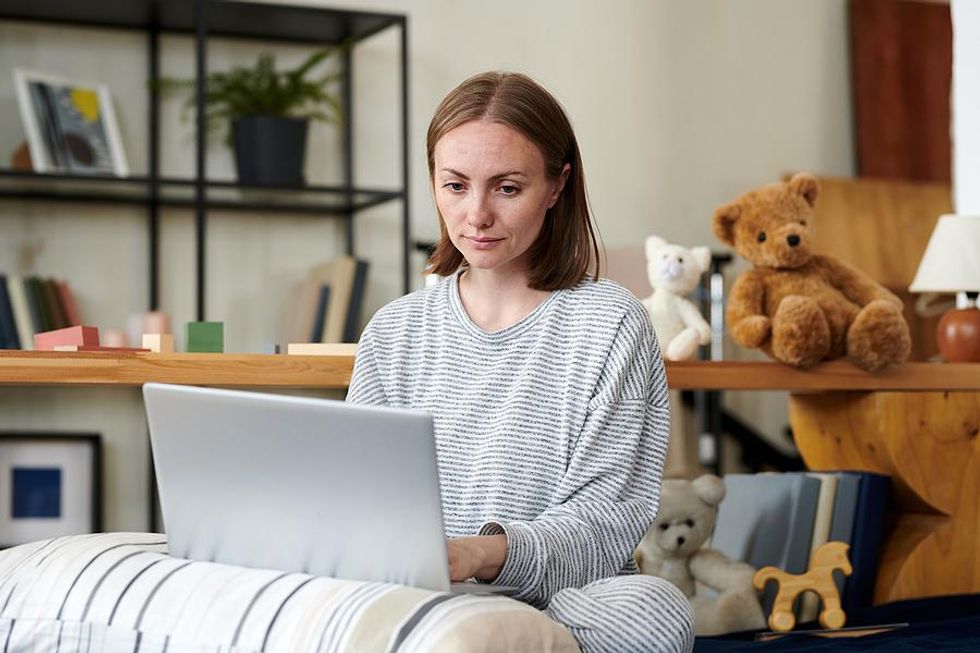 Serious woman looks for a job on her laptop