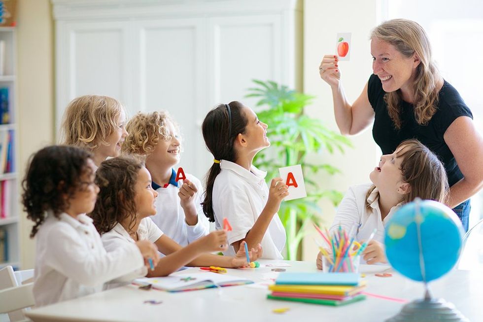 Students listen to a teacher during a classroom lesson