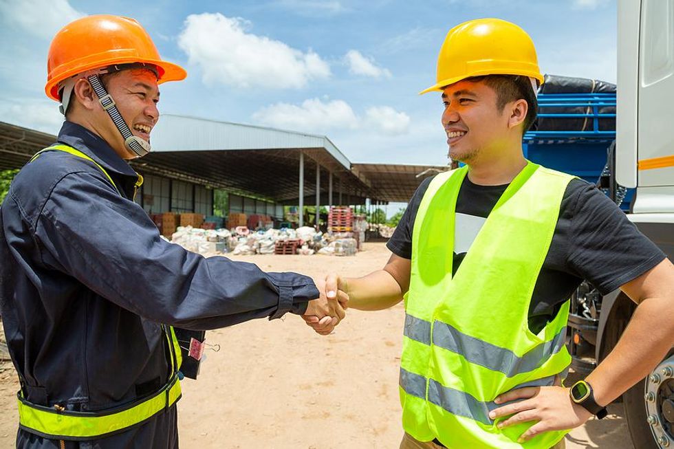 Two workers following workplace safety guidelines