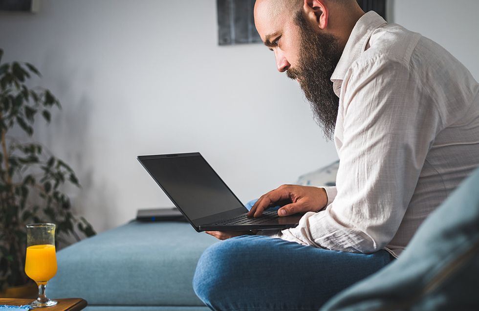 Unemployed man on laptop makes the mistake of posting his resume on job boards