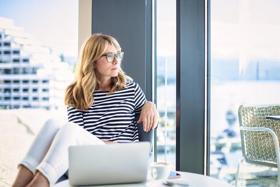 Woman looks out the window at her desk job
