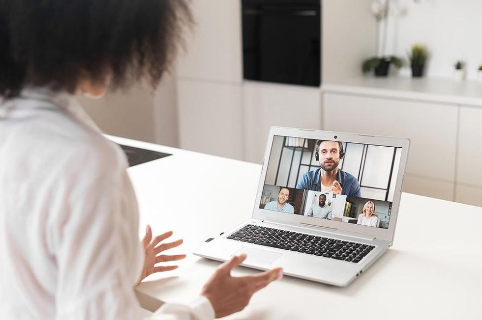 Woman on a working vacation attends a Zoom video meeting