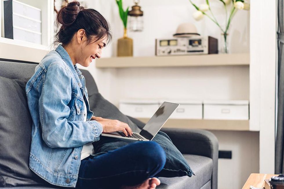 Woman on laptop connects with someone while networking online