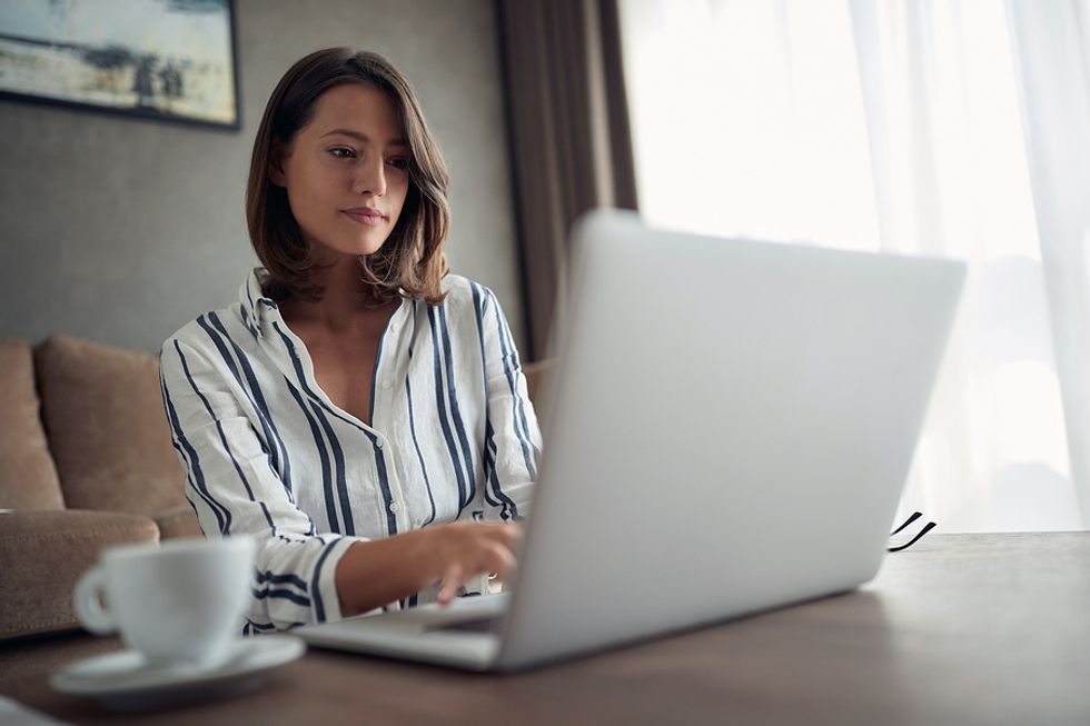 Woman on laptop looking over her resume and tailoring it for a leadership position