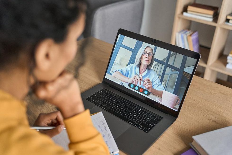 Woman on laptop networks virtually on a video call