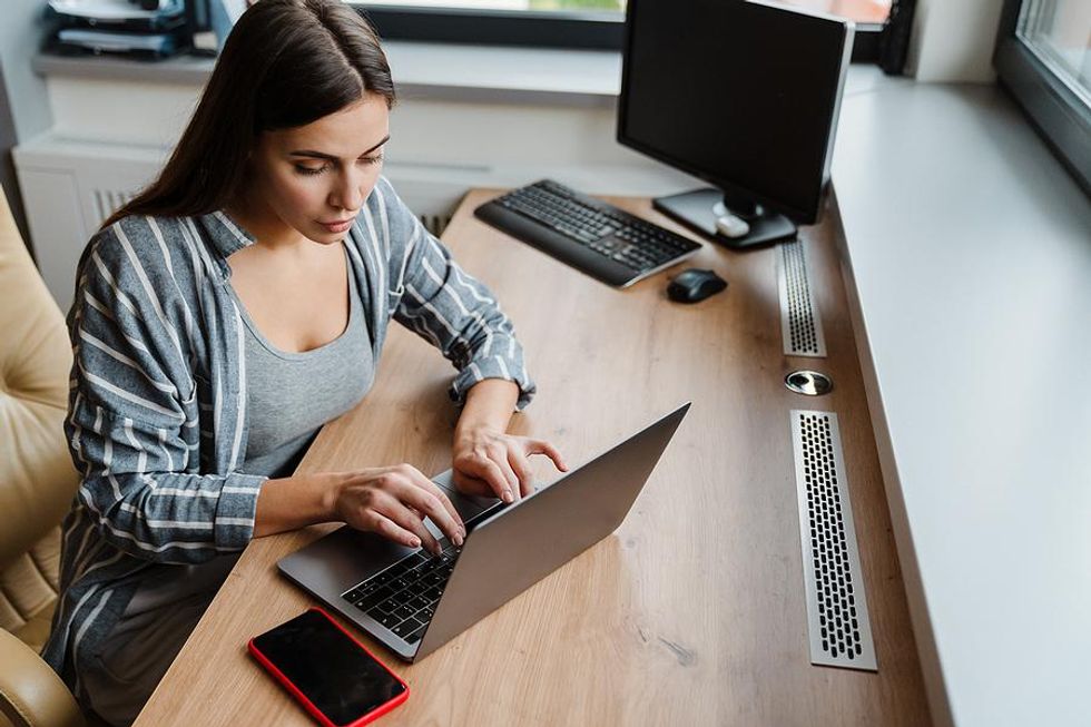 Woman on laptop removes outdated and irrelevant information from her resume