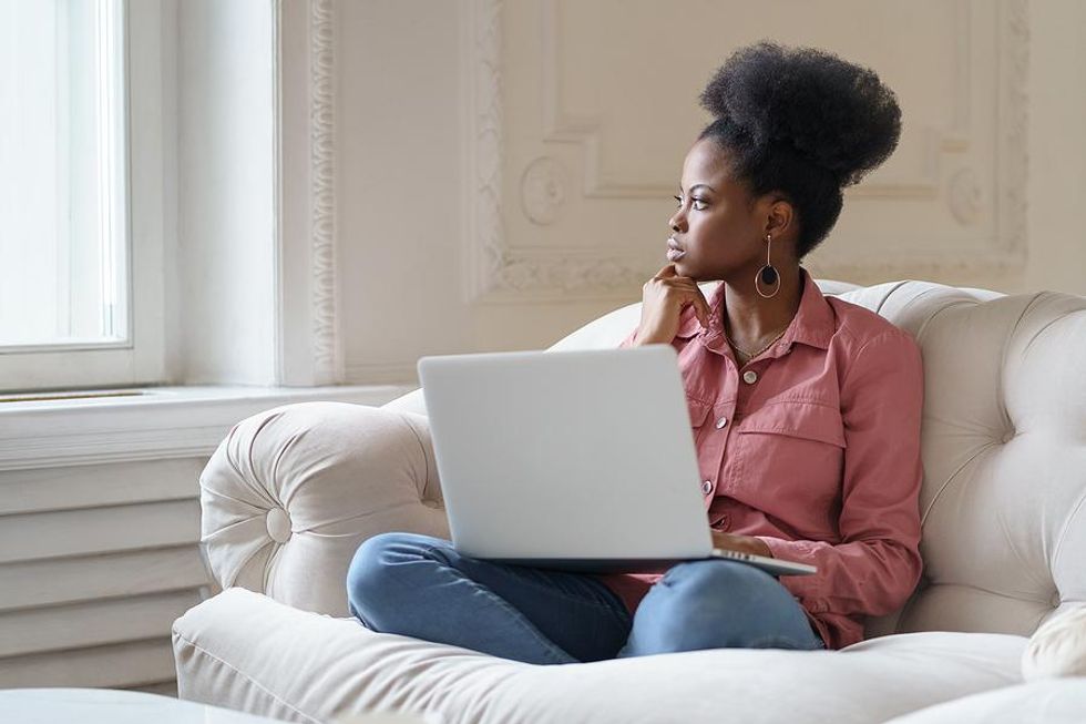 Woman on laptop thinks about her job search