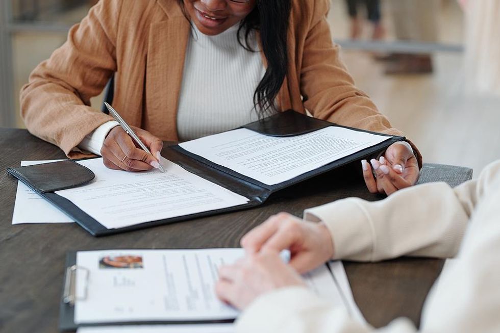 Woman signs an employment contract after a job interview
