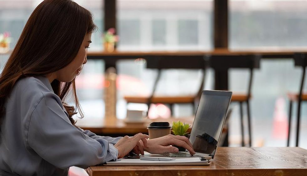 https://www.workitdaily.com/media-library/young-woman-at-a-cafe-while-working-at-her-entry-level-remote-job.jpg?id=25893586&width=980