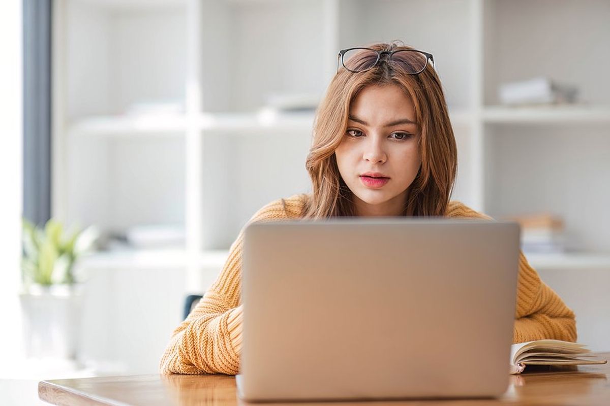 Young woman on laptop recognizes the warning signs that a job posting is fake