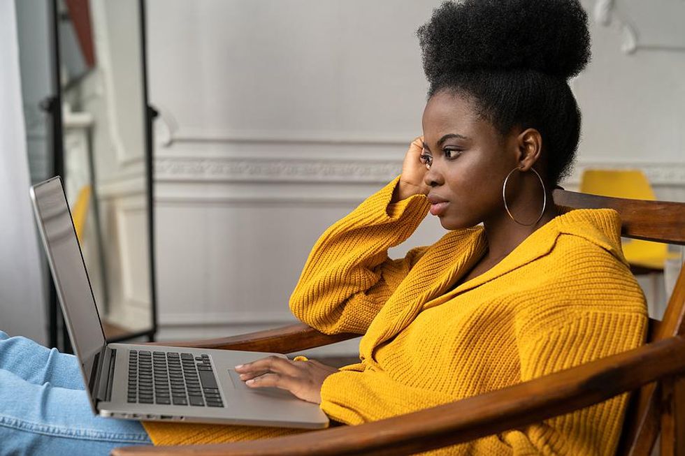 Young woman on laptop removes information from her resume